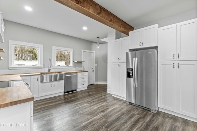 kitchen with beam ceiling, a sink, white cabinetry, recessed lighting, and stainless steel appliances