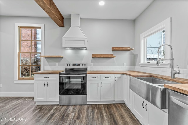 kitchen with premium range hood, open shelves, a sink, stainless steel appliances, and butcher block counters