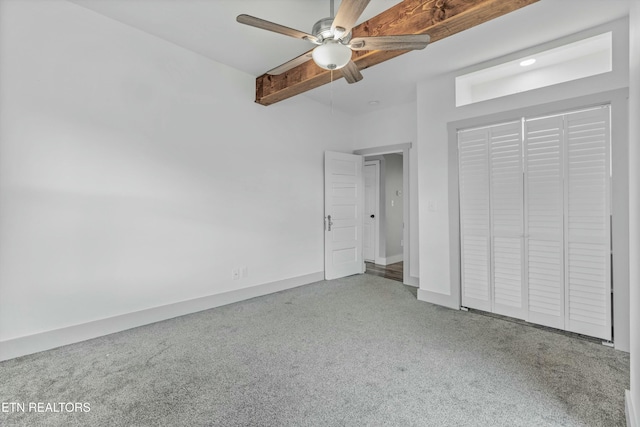 unfurnished bedroom featuring beamed ceiling, a closet, carpet, baseboards, and ceiling fan