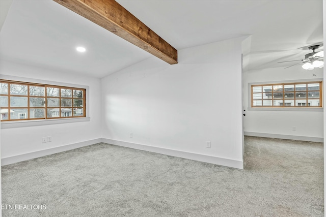 carpeted spare room featuring beamed ceiling, baseboards, a healthy amount of sunlight, and a ceiling fan