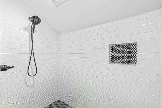 full bathroom with tiled shower and vaulted ceiling