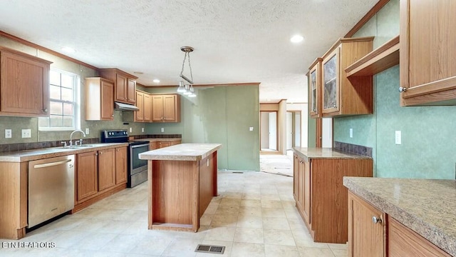 kitchen with under cabinet range hood, a kitchen island, a sink, visible vents, and appliances with stainless steel finishes