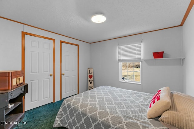 bedroom with a textured ceiling, carpet floors, and ornamental molding