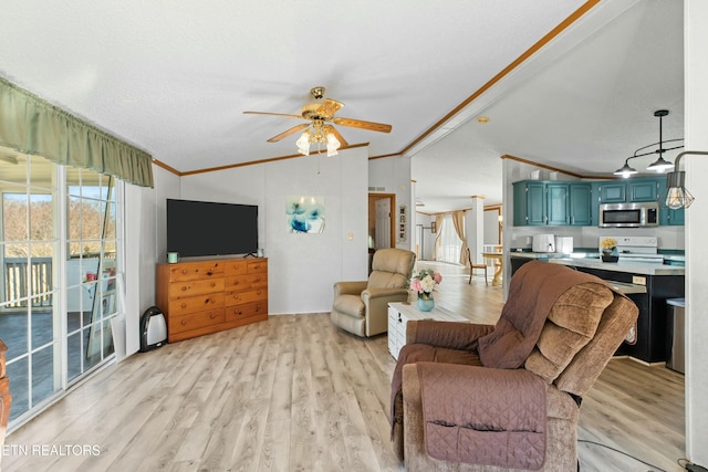 living area with light wood-style floors, ceiling fan, ornamental molding, and vaulted ceiling