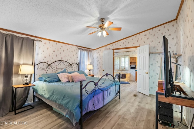 bedroom with wallpapered walls, lofted ceiling, ornamental molding, a textured ceiling, and light wood-style floors