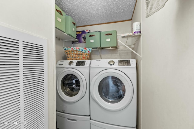 laundry room with ornamental molding, washer and clothes dryer, and a textured ceiling