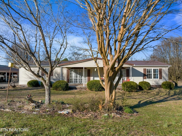 ranch-style home with a front yard and metal roof