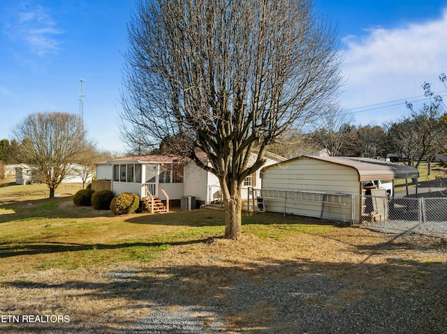 view of front facade with entry steps, a sunroom, fence, a front lawn, and a carport