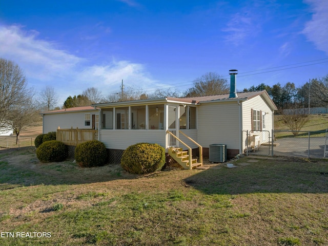 back of house with a lawn, central AC unit, a sunroom, a gate, and metal roof