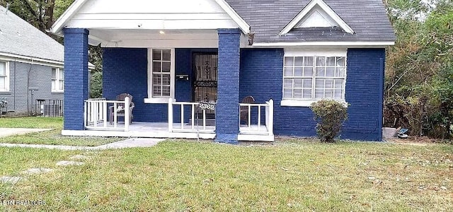 view of front of property with a porch, a front lawn, and brick siding