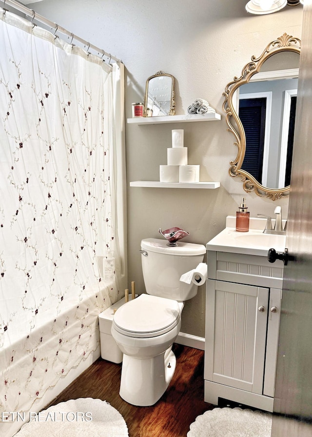 full bathroom with toilet, shower / tub combo, wood finished floors, and vanity