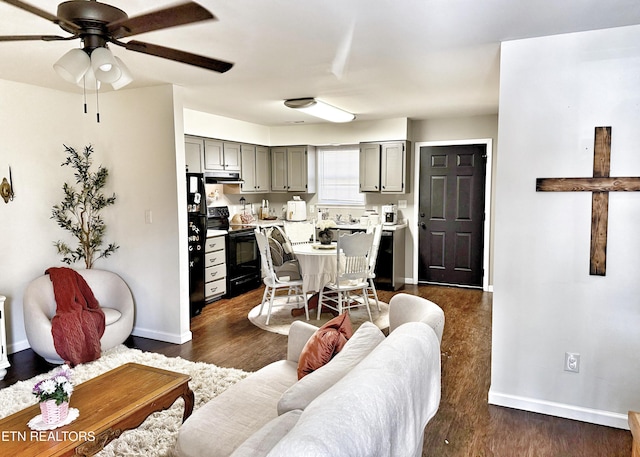 living area featuring a ceiling fan, baseboards, and dark wood-style flooring