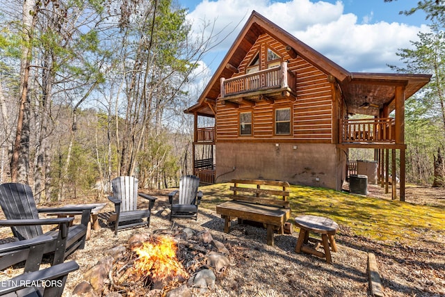 back of property featuring an outdoor fire pit, stairs, central AC, a balcony, and a ceiling fan