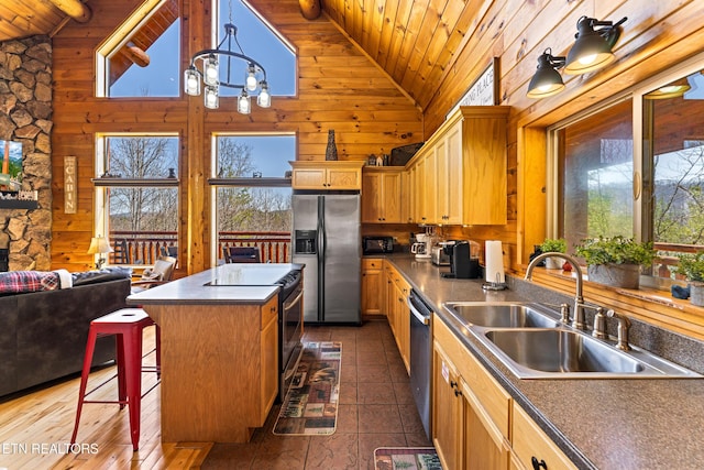 kitchen with a breakfast bar area, wood ceiling, appliances with stainless steel finishes, and a sink