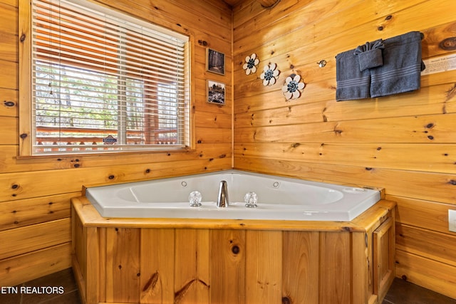 bathroom with a bath and wooden walls