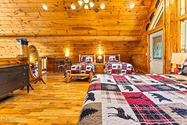 bedroom featuring vaulted ceiling, wood finished floors, and wood walls