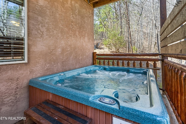 wooden deck featuring an outdoor hot tub