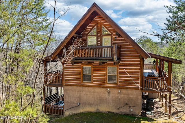 view of side of property with stairway and central AC