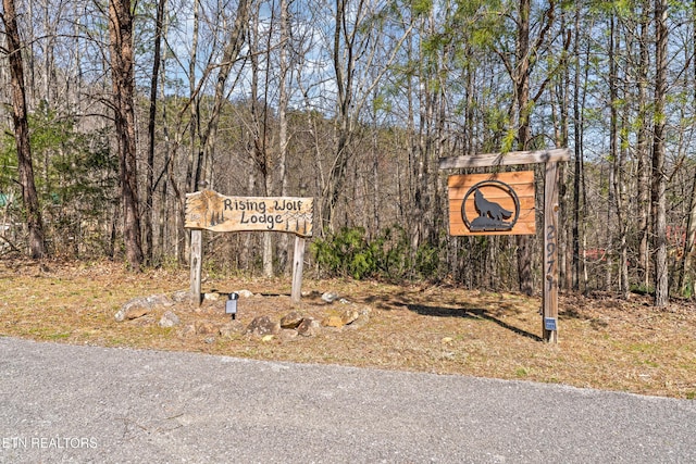 community / neighborhood sign with a forest view