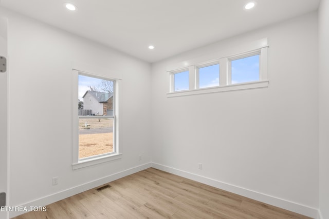 spare room featuring recessed lighting, light wood-type flooring, and a healthy amount of sunlight