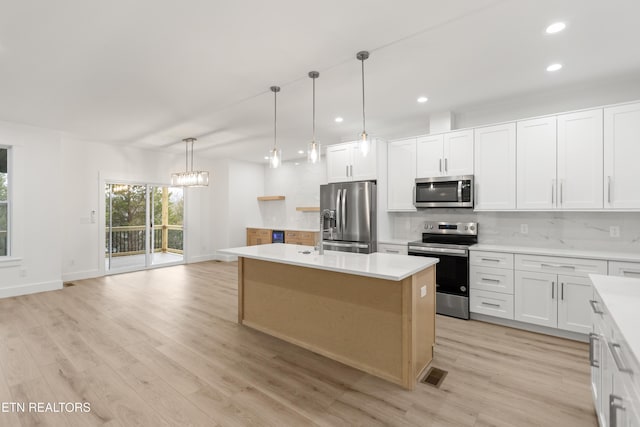 kitchen with visible vents, backsplash, stainless steel appliances, and light countertops