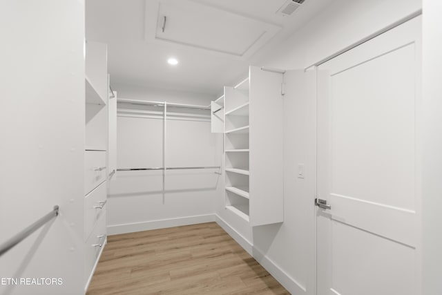 spacious closet featuring light wood-type flooring, visible vents, and attic access