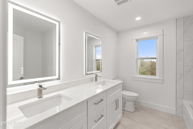 bathroom featuring double vanity, toilet, baseboards, and a sink