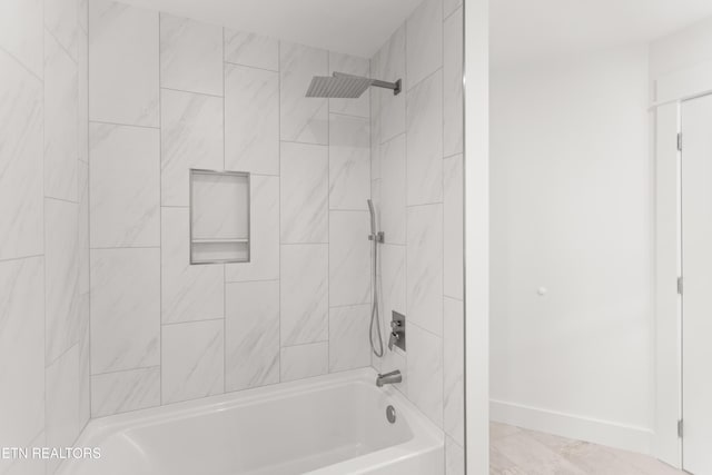 bathroom with shower / tub combination and baseboards