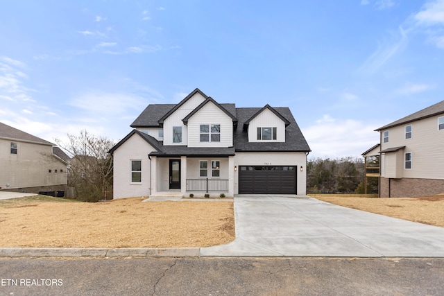 modern farmhouse featuring a garage, covered porch, concrete driveway, and a shingled roof