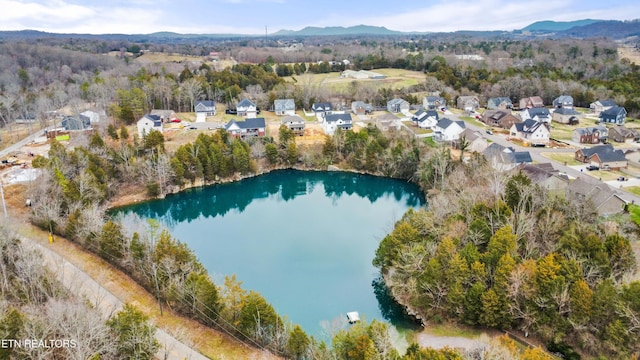 birds eye view of property featuring a residential view, a water and mountain view, and a view of trees