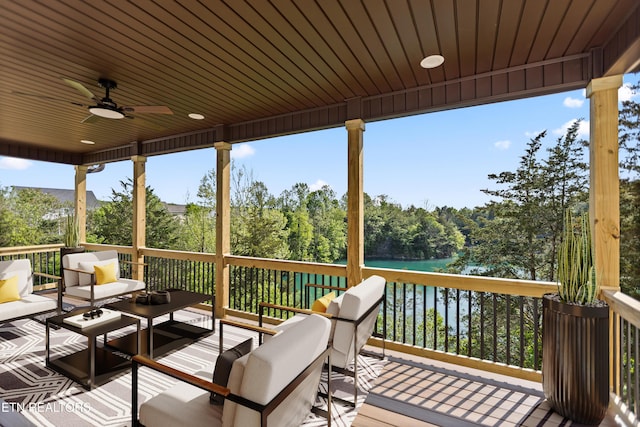 wooden deck featuring an outdoor hangout area, a water view, and a ceiling fan