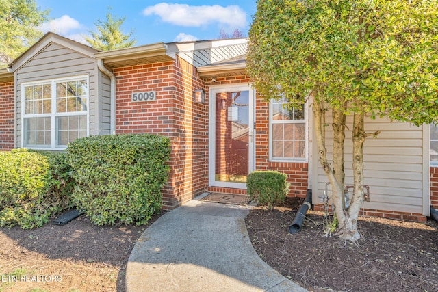 doorway to property with brick siding