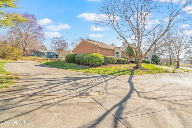 view of property exterior with a lawn and brick siding