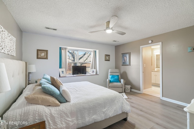 bedroom featuring visible vents, connected bathroom, ceiling fan, baseboards, and light wood-style floors