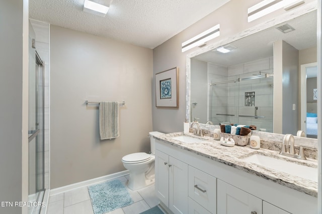 full bathroom with a stall shower, toilet, a textured ceiling, and a sink