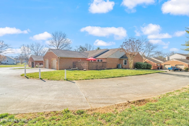 view of side of property with brick siding, a residential view, a lawn, driveway, and an attached garage