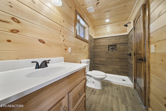 bathroom with toilet, wooden walls, vanity, wood ceiling, and a stall shower