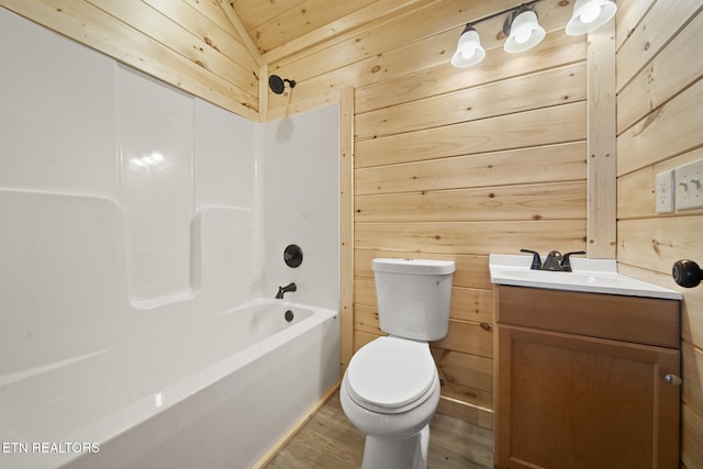 full bathroom with toilet, wood walls, wood finished floors, and vanity