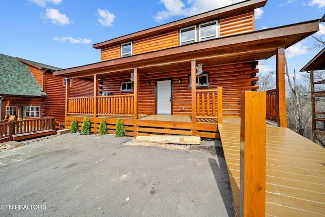 log-style house with a porch and log exterior