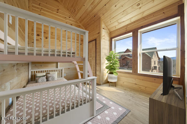 bedroom featuring lofted ceiling, wood walls, wooden ceiling, and wood finished floors