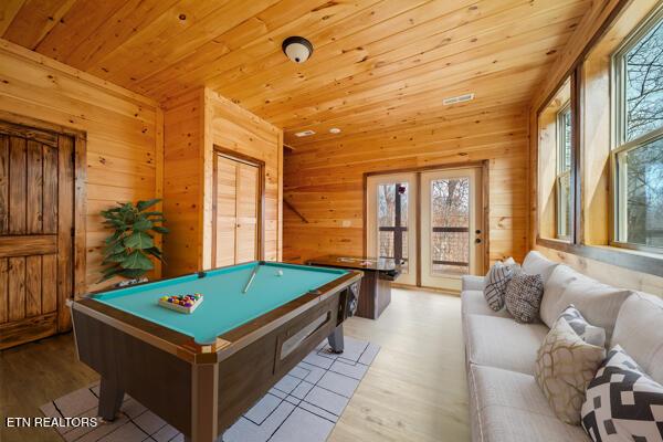 game room with a wealth of natural light, wooden ceiling, wood walls, and wood finished floors