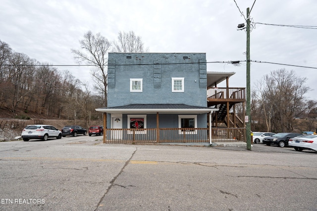 view of front facade featuring stairway and covered porch