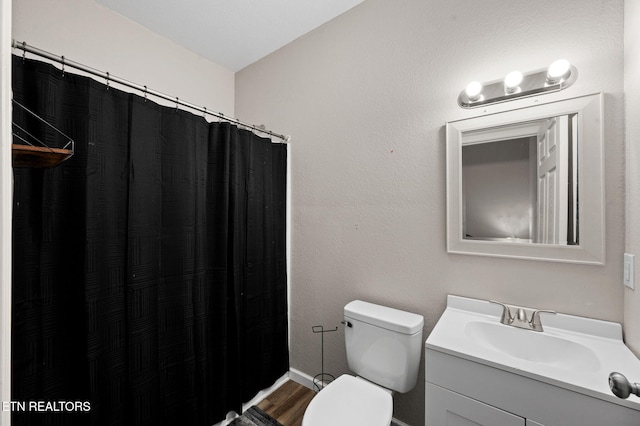 bathroom with vanity, a shower with curtain, toilet, and wood finished floors