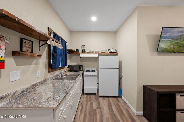 kitchen featuring white appliances, open shelves, light wood-style flooring, a sink, and white cabinets