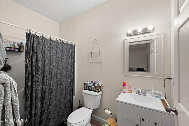 bathroom featuring baseboards, toilet, vanity, and a shower with curtain