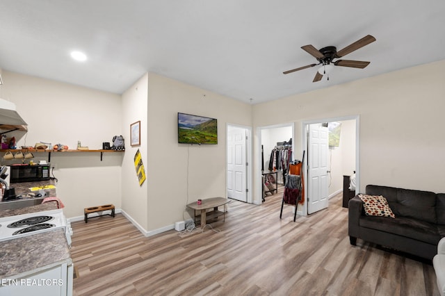 living area with recessed lighting, light wood-type flooring, baseboards, and a ceiling fan