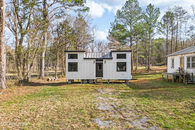 exterior space with metal roof and a front lawn