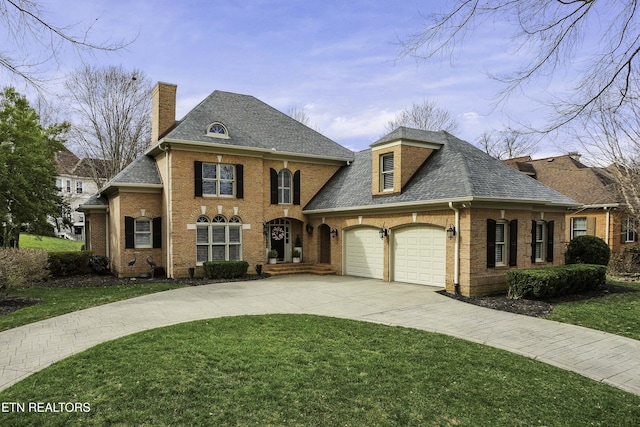 view of front of home featuring brick siding, concrete driveway, a front yard, a chimney, and a garage