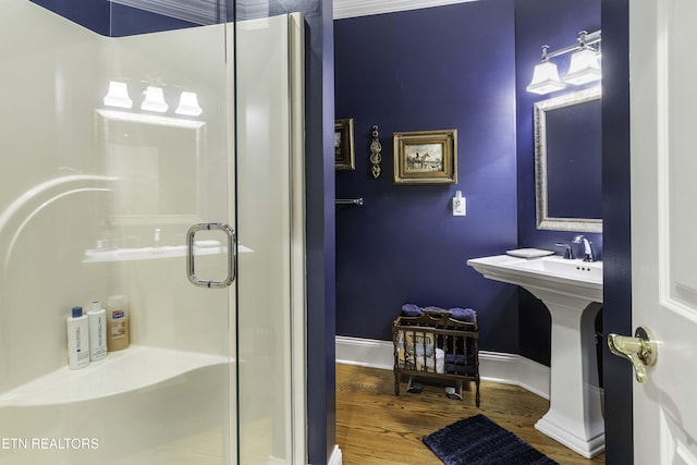 bathroom with a stall shower, baseboards, and wood finished floors