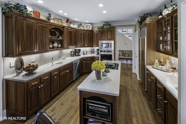 kitchen featuring wood finished floors, stainless steel appliances, light countertops, and a sink